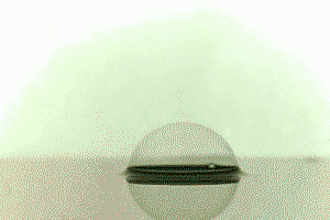 A water drop falling through a soap bubble