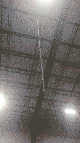 Wave in a chain attached to a factory ceiling