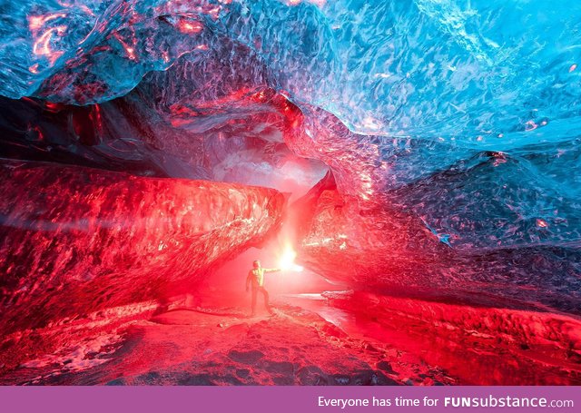 An Icelandic ice cave, lit up by a burning flare