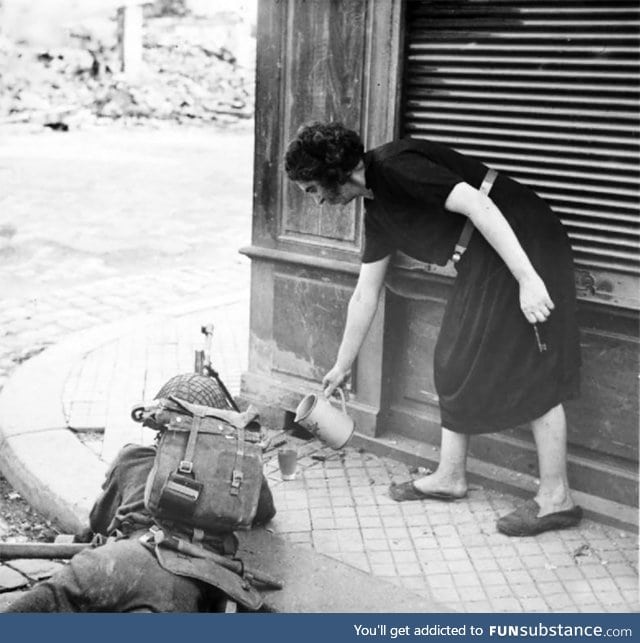 French woman pours tea to a British soldier during the fighting in Normandy, 1944