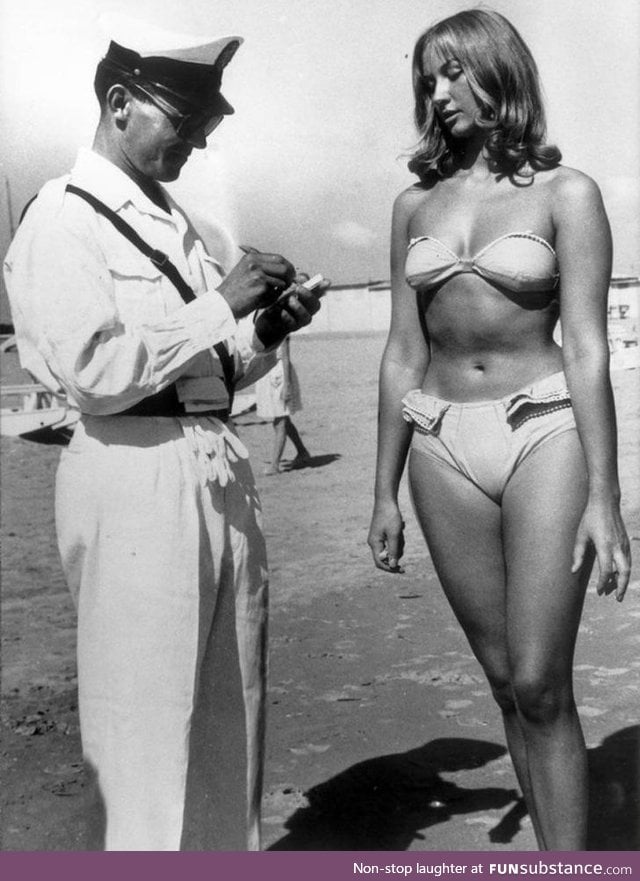 Woman receives ticket for illegally wearing a bikini on a beach. (Italy, circa 1957)