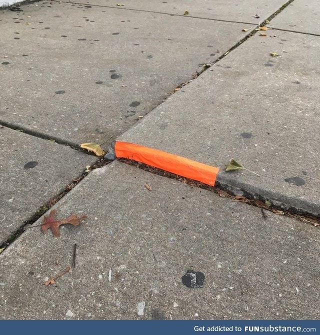 Someone put tape on this raised bit of sidewalk
