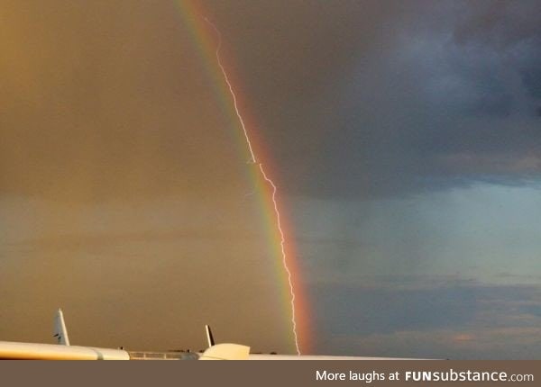 Lightning strikes through a rainbow