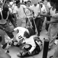 Black woman protecting a fallen racist from a crowd