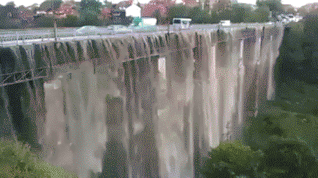 Heavy raining turns a bridge into a waterfall