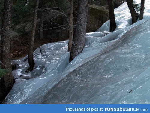 Snow melts and flash freezes into an icy downhill river