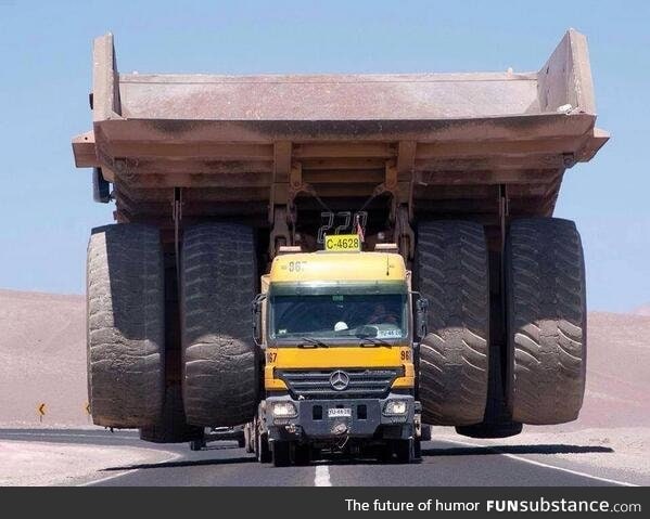 This truck transporting a massive mining truck looks like a tiny toy