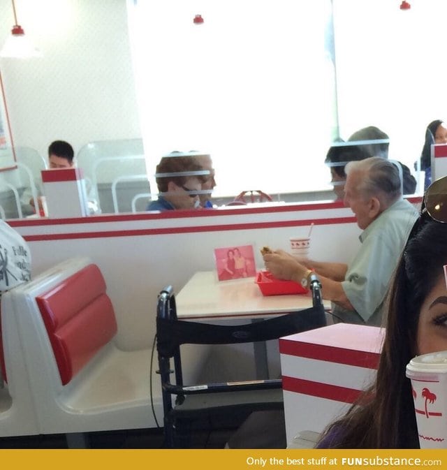 Old man eating by himself at In N Out with a picture of his wife