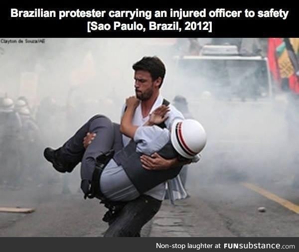 Brazilian protester carrying injured police to safety