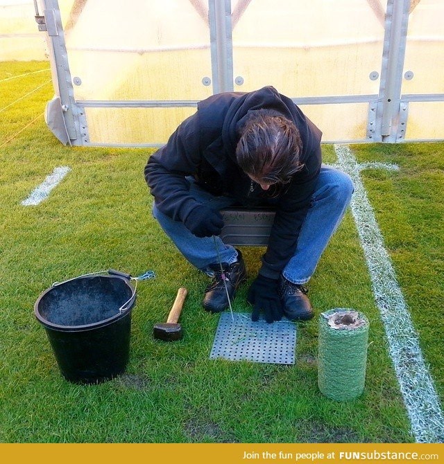 This gentleman is sewing individual strands of artificial grass into bare spots