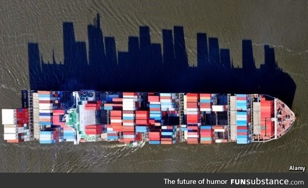 Cargo ships supply a city with goods. The shadow of this one looks like a cityscape