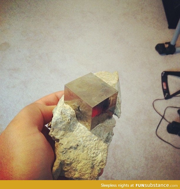 This is a perfect cube of pyrite, in its natural rocky matrix