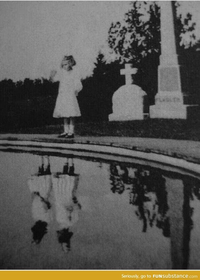 This photo was taken in 1925 of a little girl visiting her twin sister's grave