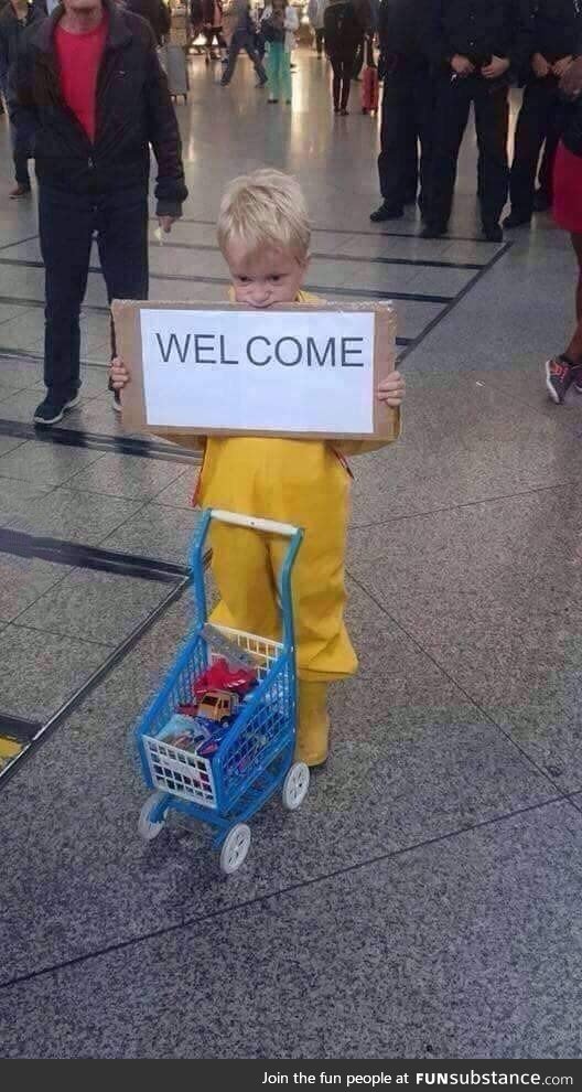 A child waits to welcome refugees at the Munich Central Station giving away what his toys