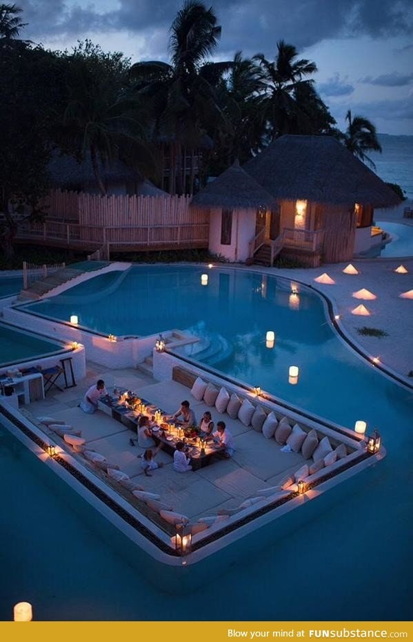 Having dinner surrounded by a swimming pool
