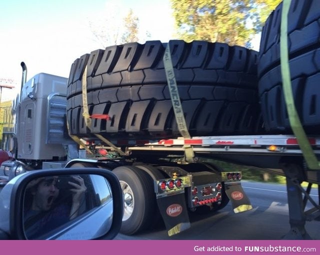 This truck is hauling tires that are wider than the truck