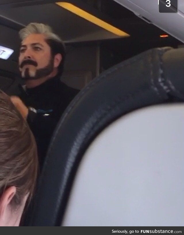 Flight attendant looks like he's about to announce some Hunger Games results