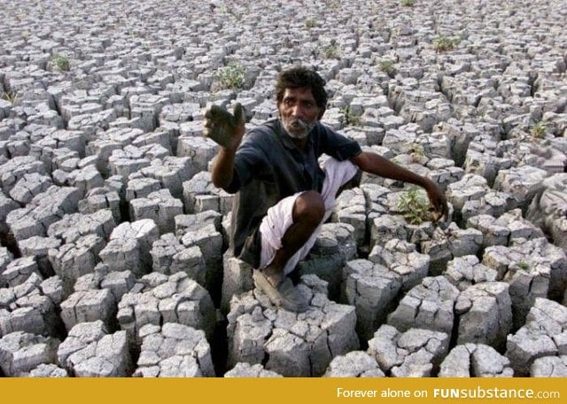 Indian farmer on his formerly productive land now rendered barren by drought