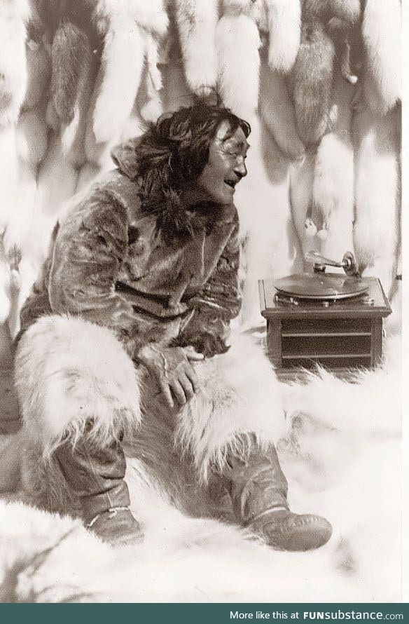 An Eskimo man enjoying some music on a record player in 1922