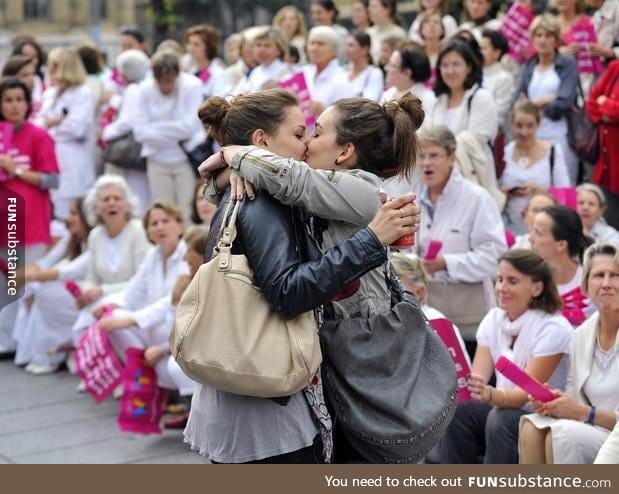 Lesbian couple kisses in front of an anti-gay parade in France