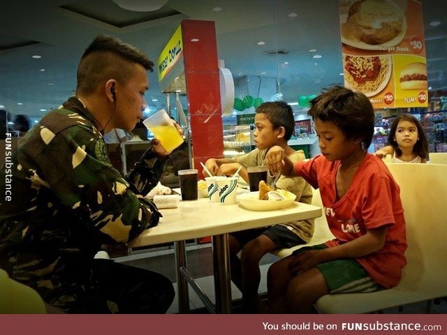 Philippine Air Force man buying meals for two street children