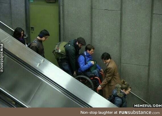 The Canadian Prime Minister helping a man in a wheelchair when the escalator broke down