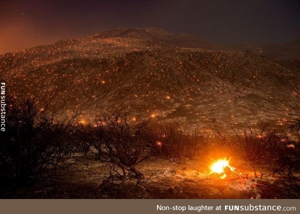 Embers from a wildfire smolder along Lytle Creek Road near Keenbrook, California