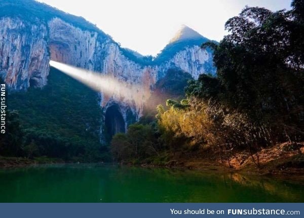 A ray of light shines through the Great Arch of Getu in China