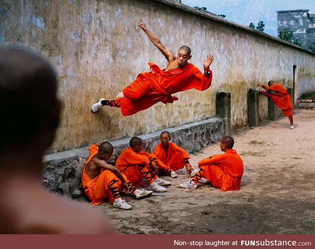 Monk running along wall, Hunan Province, China