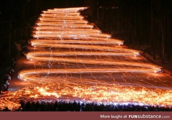 Long exposure of hundreds of skiers holding flashlights