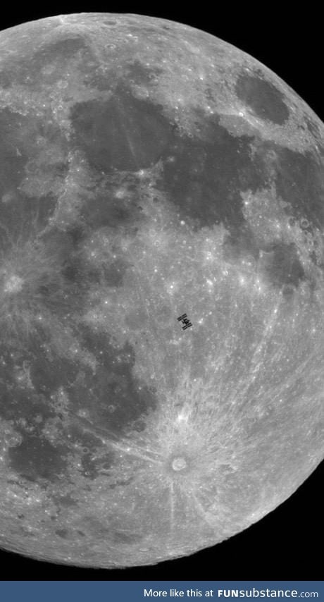 The international space station silhouetted by the moon