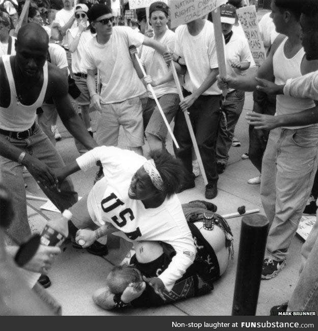 Black woman protecting a fallen racist from a crowd