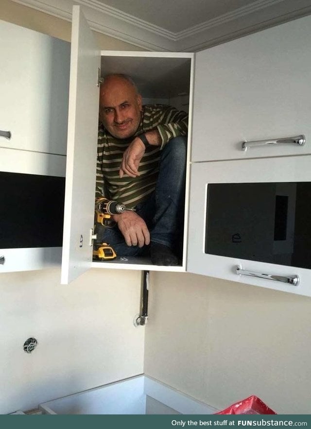 Contractor gets in the cabinet he just build to prove its sturdiness
