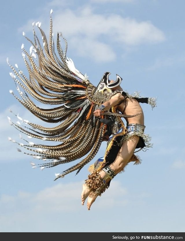 Man in traditional Aztec garb jumping