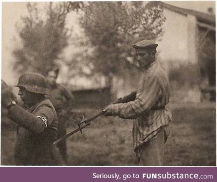 Jewish prisoner, recently liberated from a concentration camp, aiming a gun at a nazi