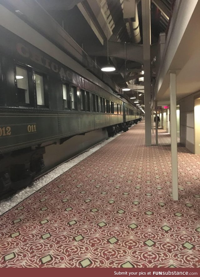 This hotel I'm at has a train inside it with rooms inside of it