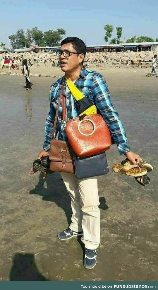 A married man enjoying a holiday with his wife and kids at a beach