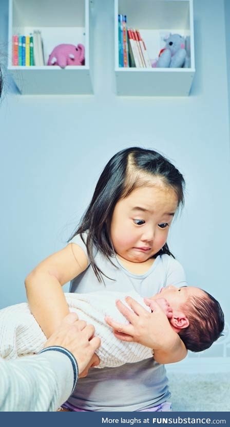 A child's reaction when holding her new baby sister. Much heavier than the dolls she