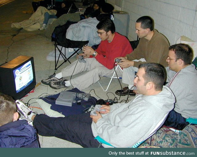 A group of guys outside Best Buy playing PS1 while waiting in line for the greatly