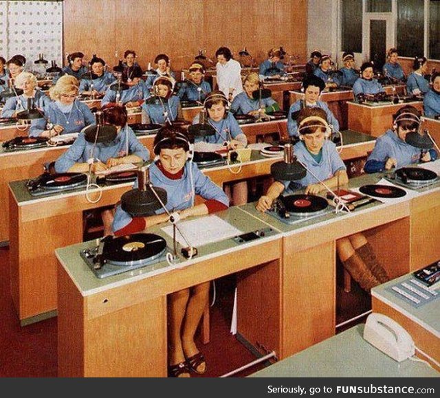 Employees at a record company listening to each record to verify quality before shipment