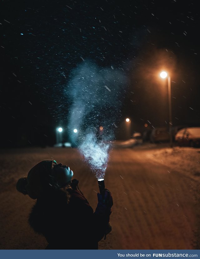 My daughter holding a flashlight in snowy weather