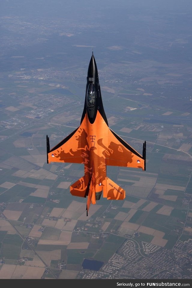 A Dutch F-16 Falcon above a typical Dutch landscape