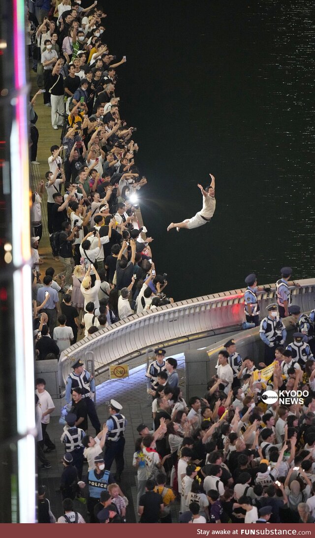 A man dive into Dotonbori after Hanshin Tigers had won the first league title in 18 years