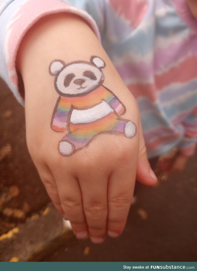 A rainbow panda painted on my kids' hand at a recent neighborhood fair