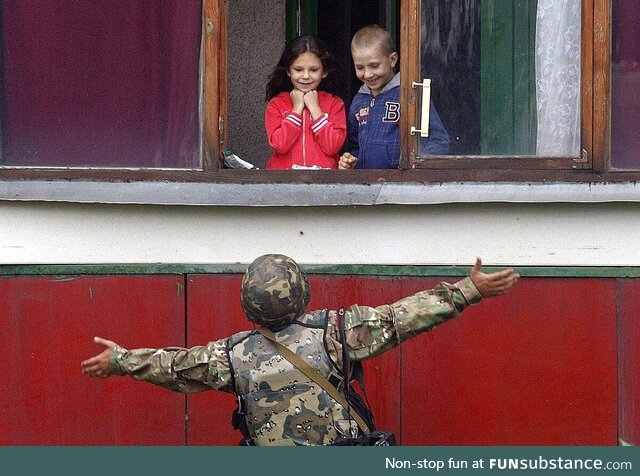 A Ukranian soldier cheers up children after freeing their city from Russian forces (2014)