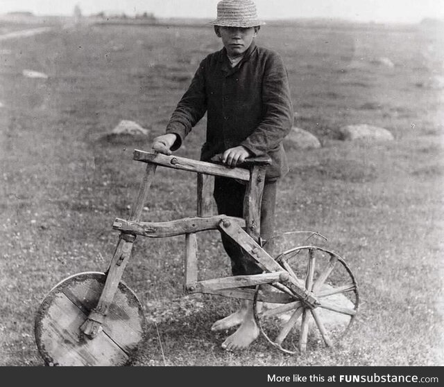 A kid with a self-made wooden bicycle, 1912