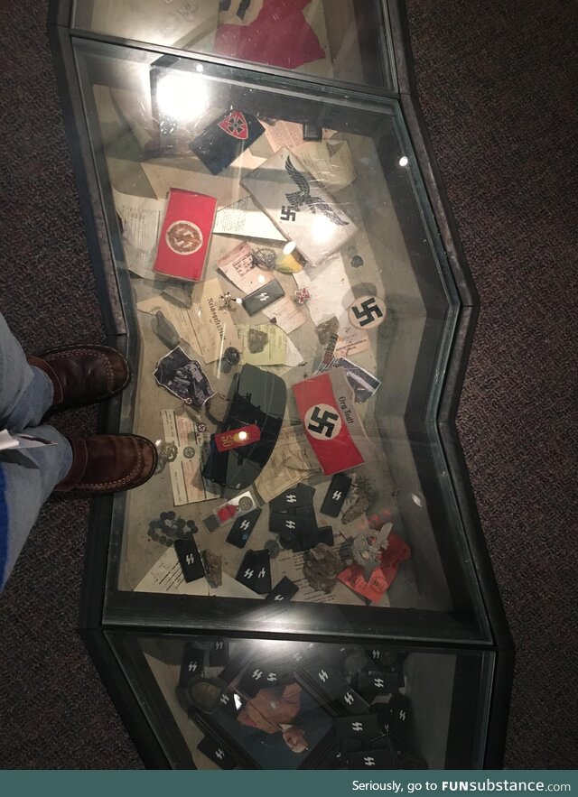 A case of Nazi paraphernalia set in the floor of a Holocaust museum, forcing visitors to