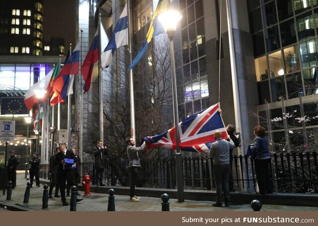 The UK flag being removed from the flagpoles showing the European Parliament; From
