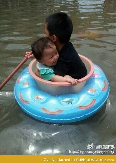 Big brother saving little sister from flood water