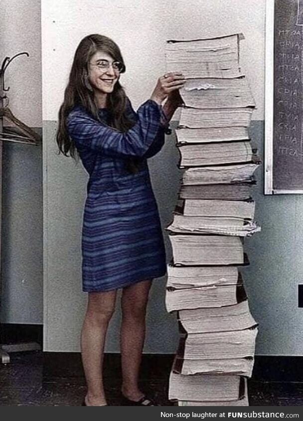 Margaret Hamilton standing by the code that she wrote by hand to take humanity to the